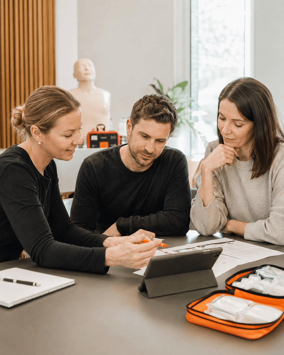 Trois personnes préparent le suivi d’une formation autour d’un plan d’action.